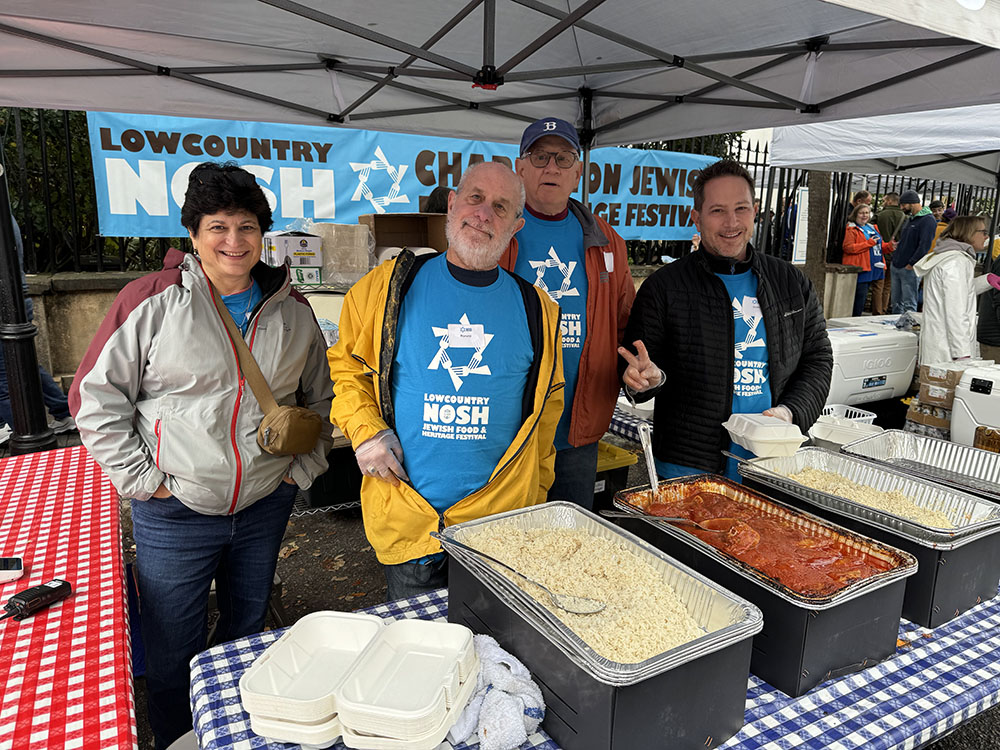 Men and women at a food tent serving food at the Lowcountry Nosh