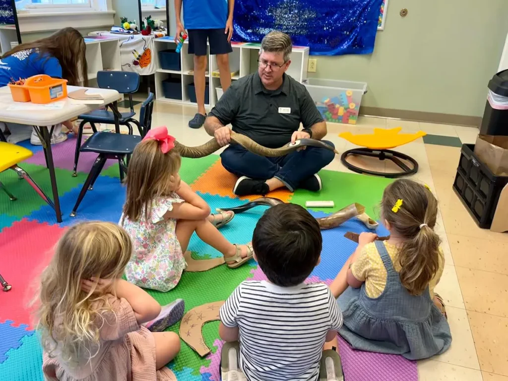 teacher showing kids a shofar