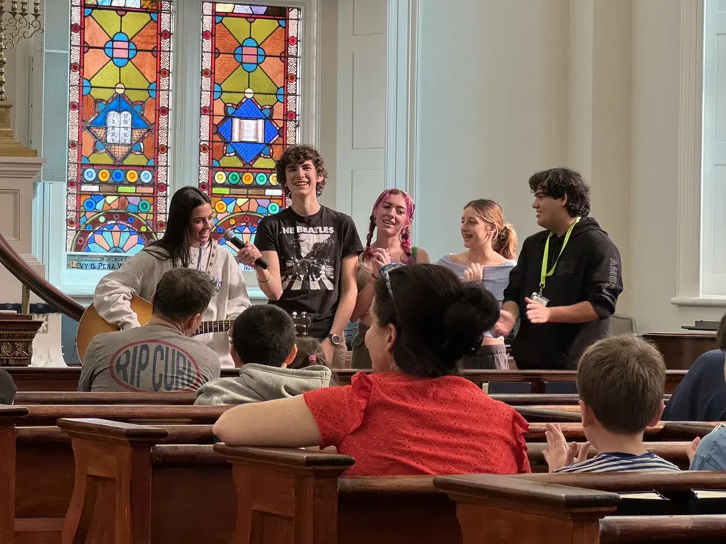 group of teens singing with a guitar