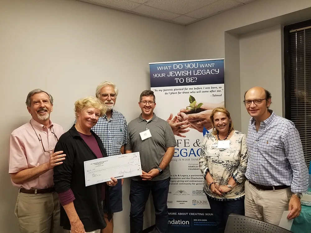 group of people holding a donation check