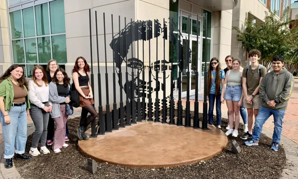 teens gathered in front of an outdoor sculpture